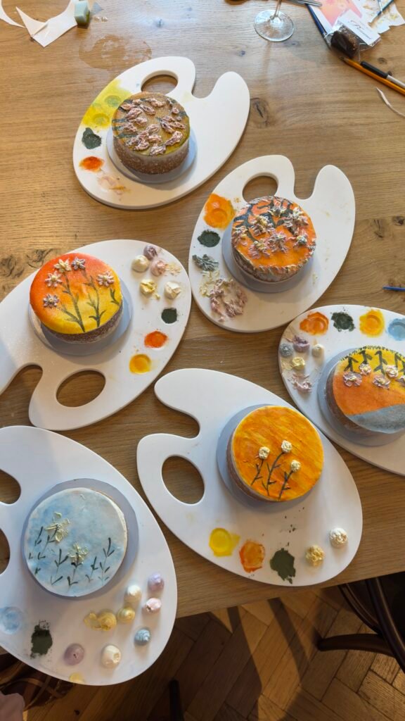Rows of freshly decorated cakes at the Good Cake Day Sip and Paint Cake Decoration. Beautiful sets of sunset inspired cake decorations